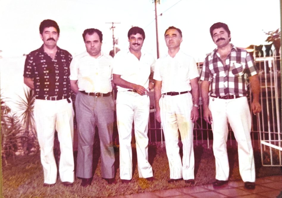 Cinco irmãos Tobias lado a lado, de camisa e calça, em foto colorida antiga